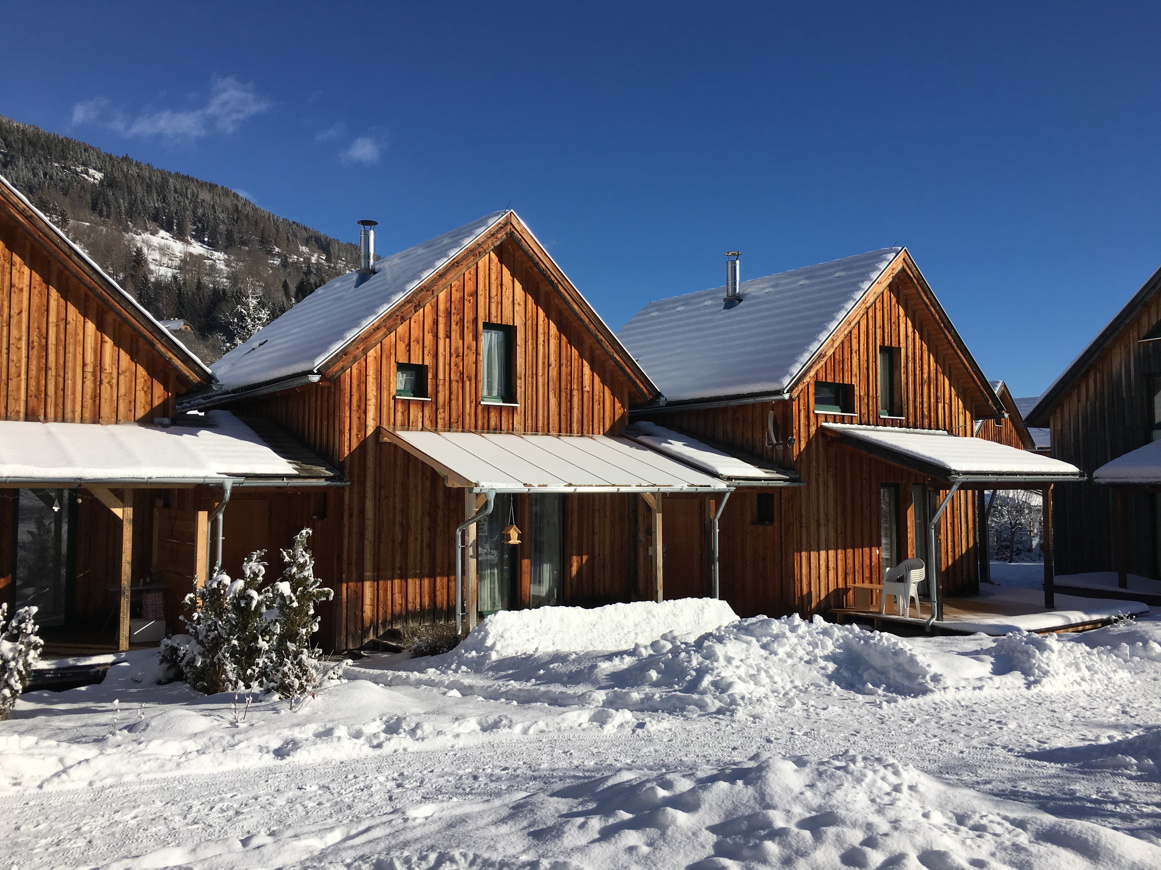 Ferienhaus am Kreischberg mit verschneitem Garten, großer mit Glasdach überdachter Terrasse.